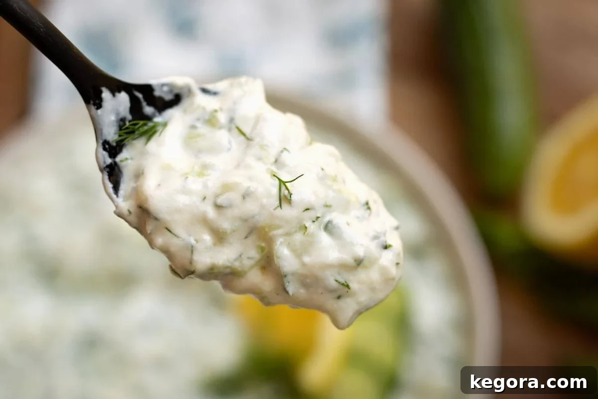 Refreshing Cucumber Yogurt Dip 3 Tzatziki Sauce on a spoon closeup, highlighting its creamy consistency.