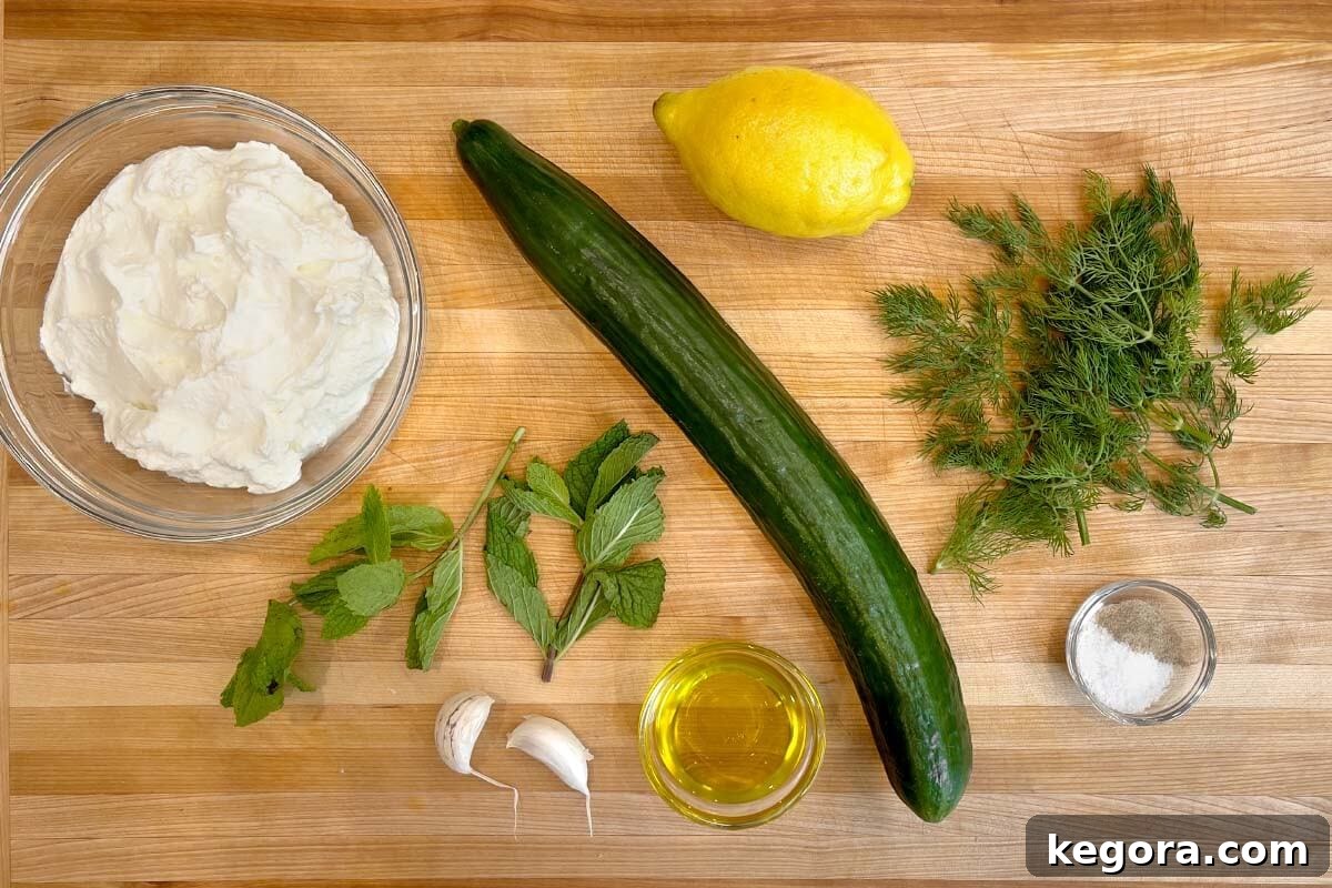 Refreshing Cucumber Yogurt Dip 4 Tzatziki Sauce ingredients shot on board, showing fresh cucumber, yogurt, herbs, and lemon.