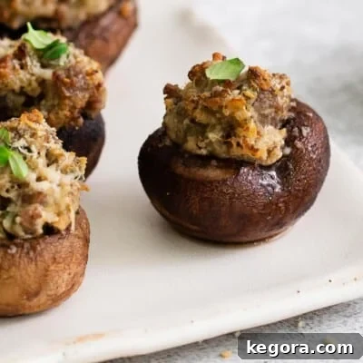 A close-up photo of a perfectly golden stuffed mushroom, garnished with fresh herbs.