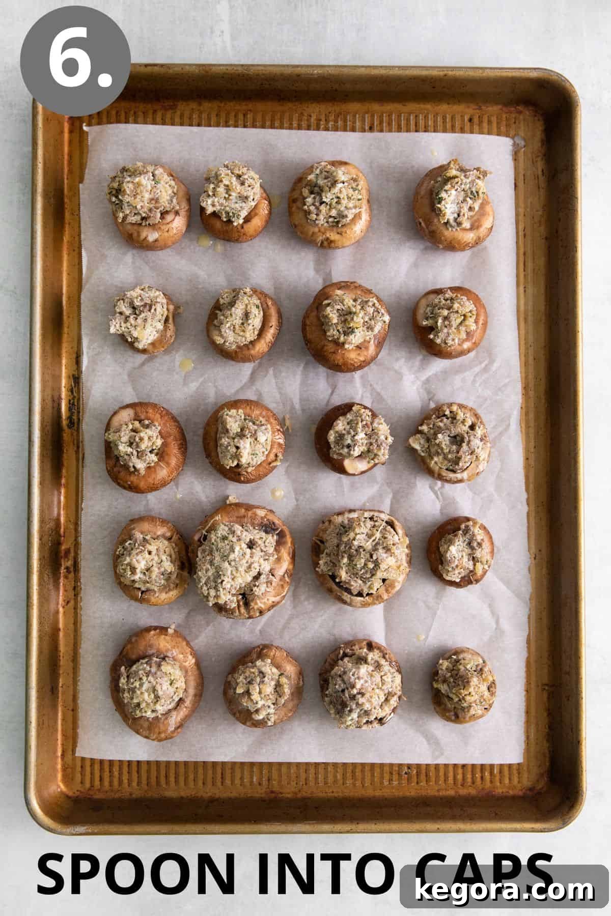 Mushroom caps generously filled with the sausage and cream cheese mixture on a baking sheet.