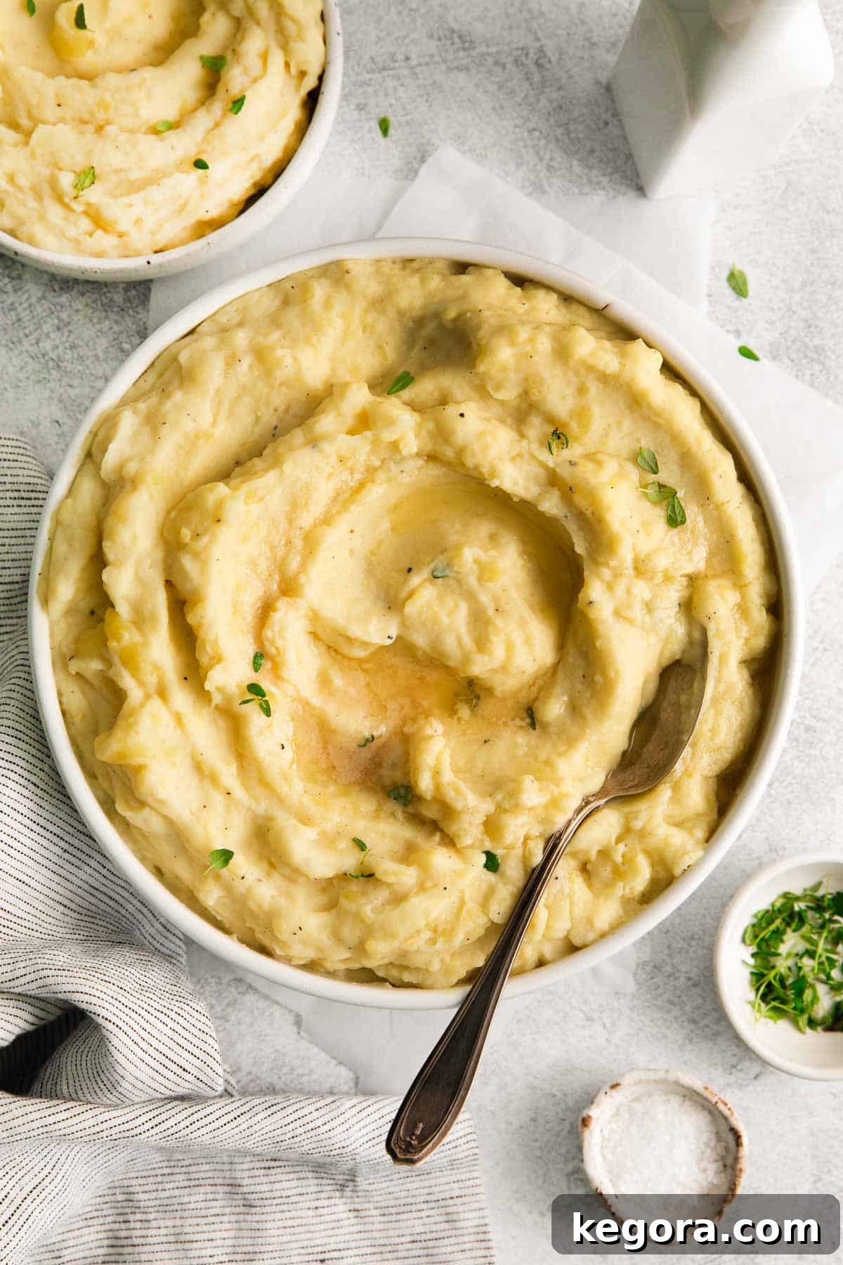 Velvety Dairy-Free Mashed Potatoes 3 Creamy dairy-free mashed potatoes in a serving bowl with a spoon scooping into the bowl.