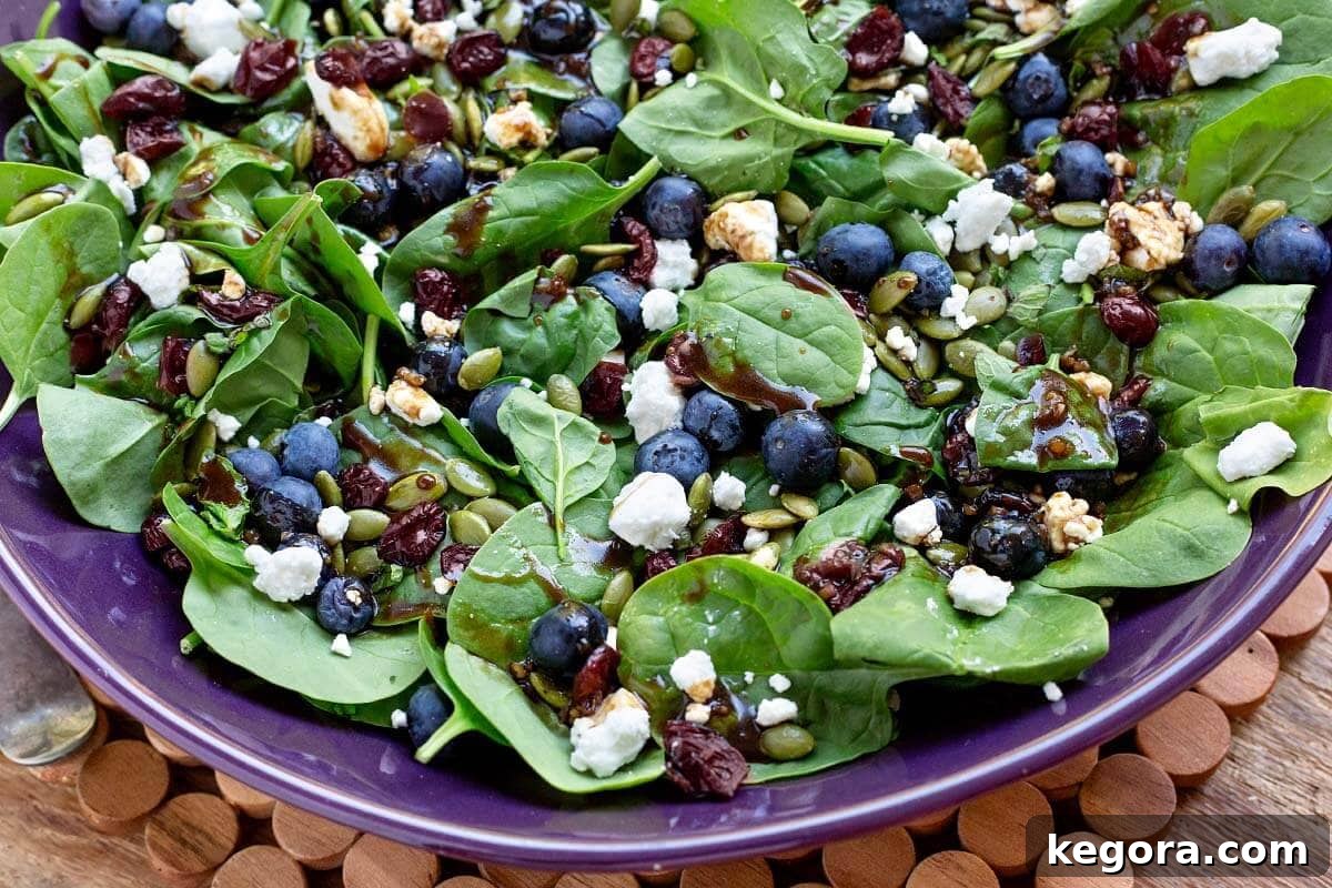 Blueberry Spinach Salad in a purple serving bowl, showcasing its colorful ingredients.