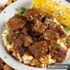 Steak Bites over mashed potatoes on plate with corn.