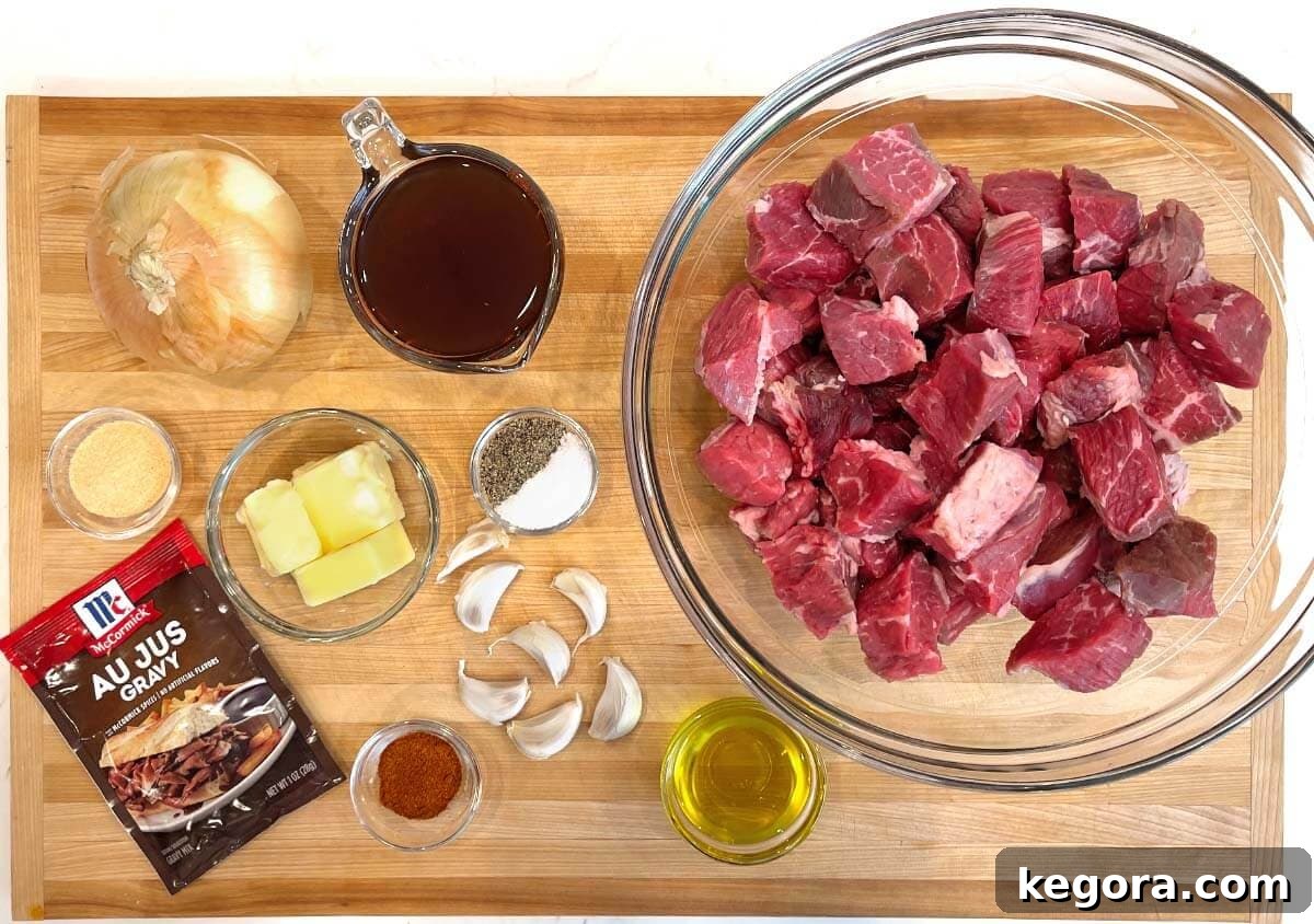 Melt-in-Your-Mouth Slow Cooker Garlic Butter Steak Bites 4 Slow Cooker Garlic Butter Steak Bites ingredients shot on a board.