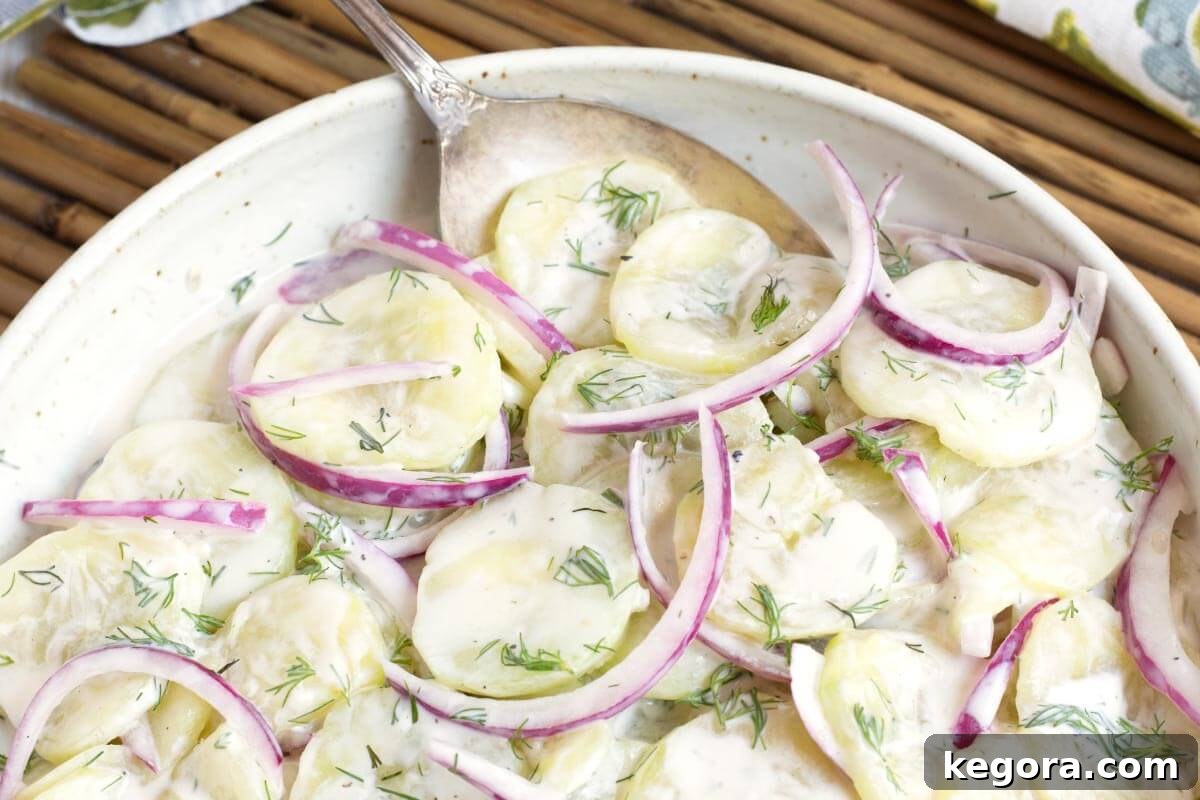 Fresh Dill Cucumber Delight 3 Creamy Dill Cucumber Salad in a bowl with a spoon closeup.