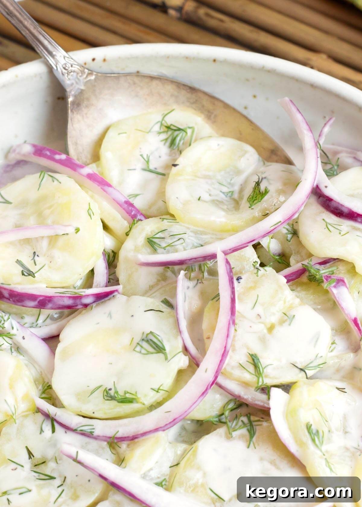 Fresh Dill Cucumber Delight 10 Salad in a white bowl with a spoon