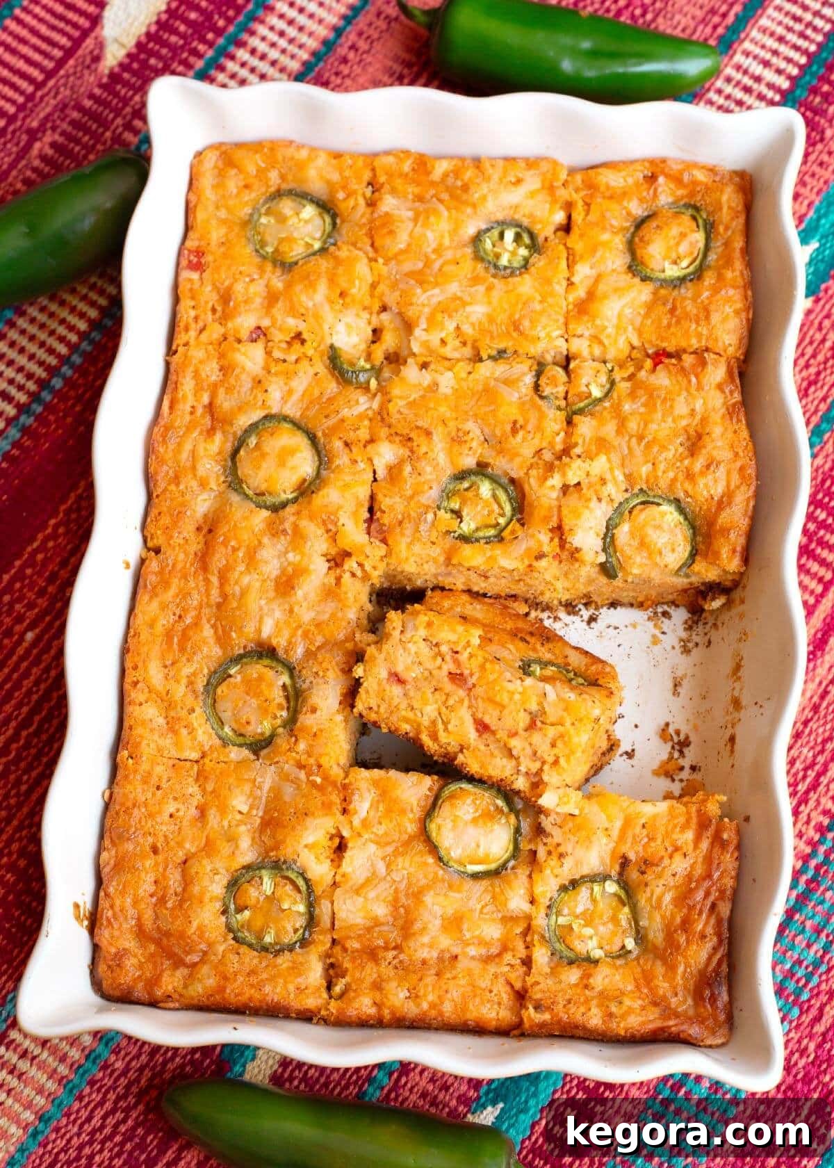 Loaded Tex-Mex Cornbread 2 Tex-Mex Cornbread in a pan, sliced, with one slice on its side