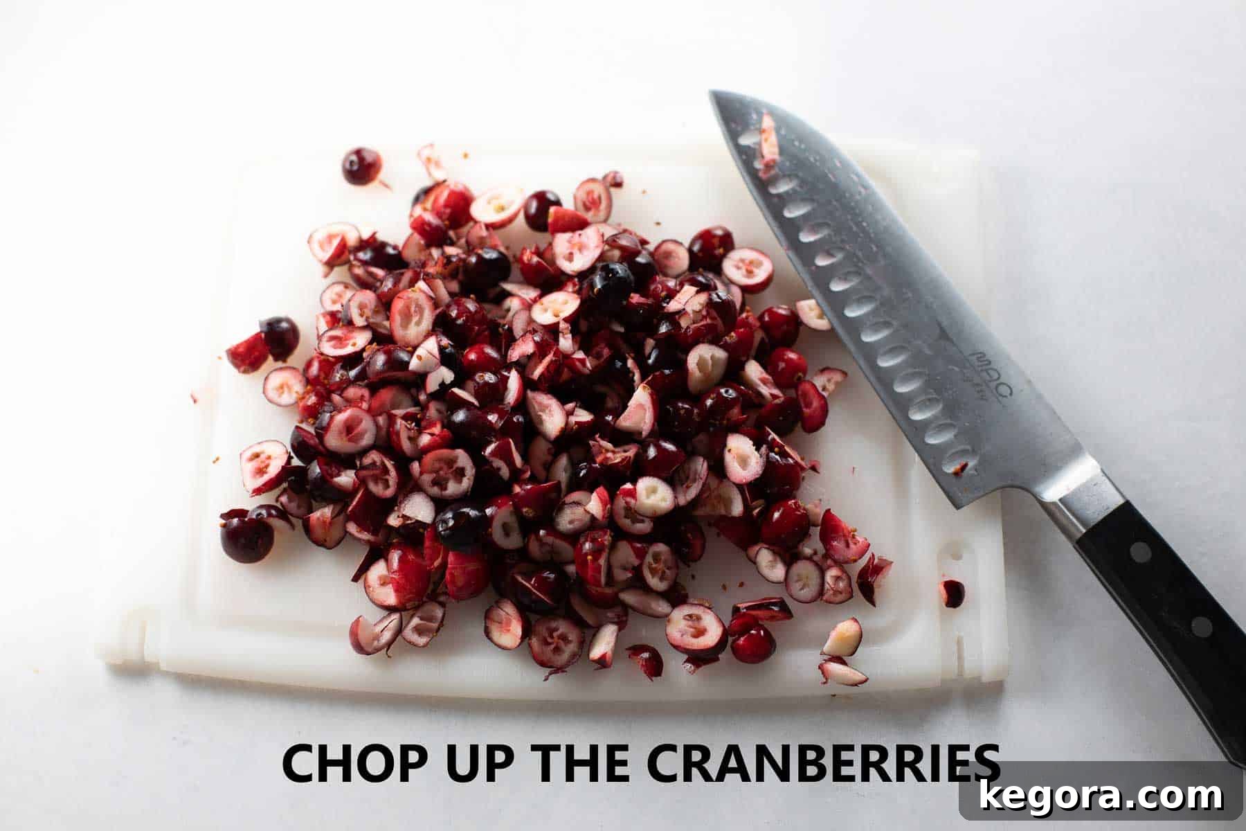 Fresh cranberries chopped on a rustic wooden cutting board, ready for baking.