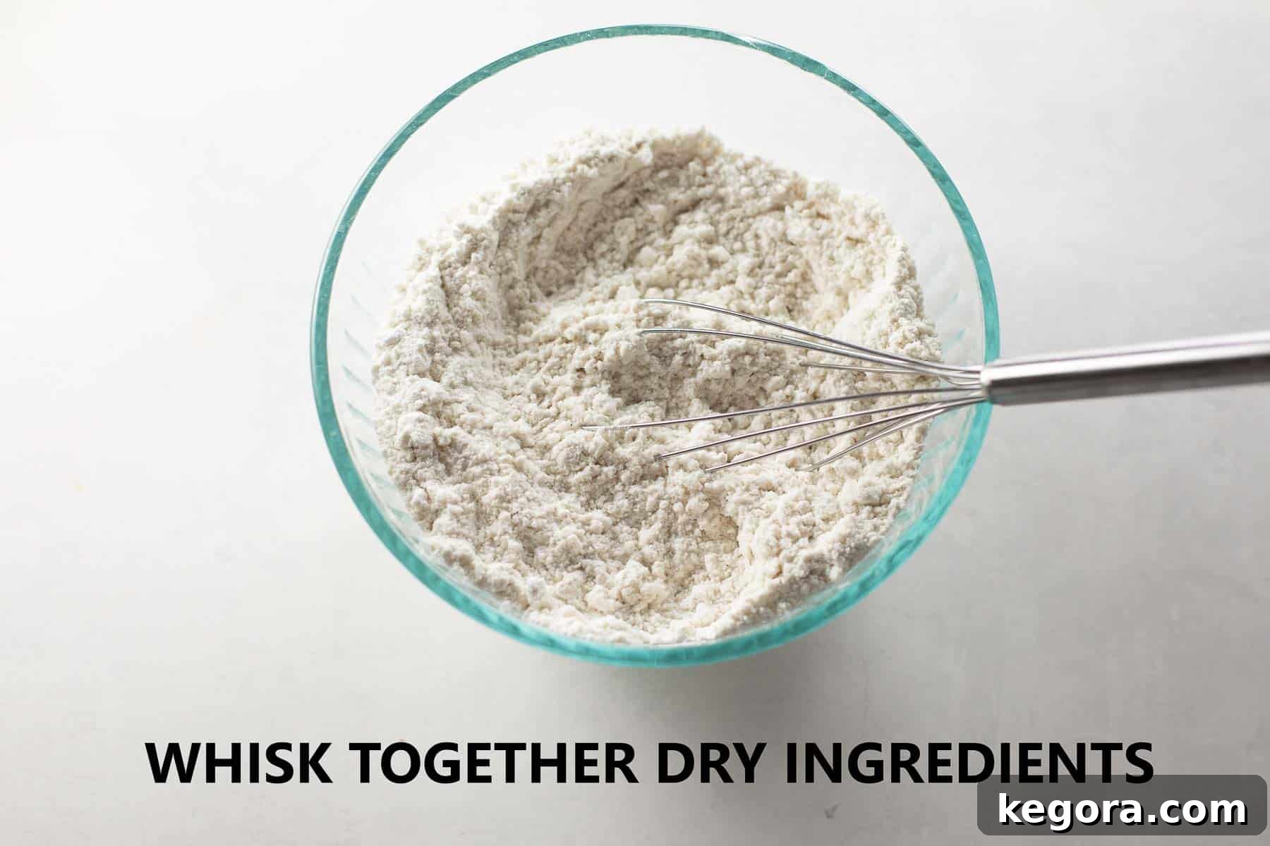 A small glass bowl filled with dry ingredients for muffins, including flour, baking powder, and salt, perfectly mixed.