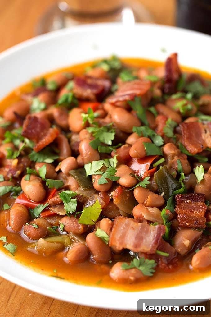Instant Pot Beer Braised Fiesta Beans 5 Close up of Drunken Beans, Frijoles Borrachos, in a white bowl on wooden board