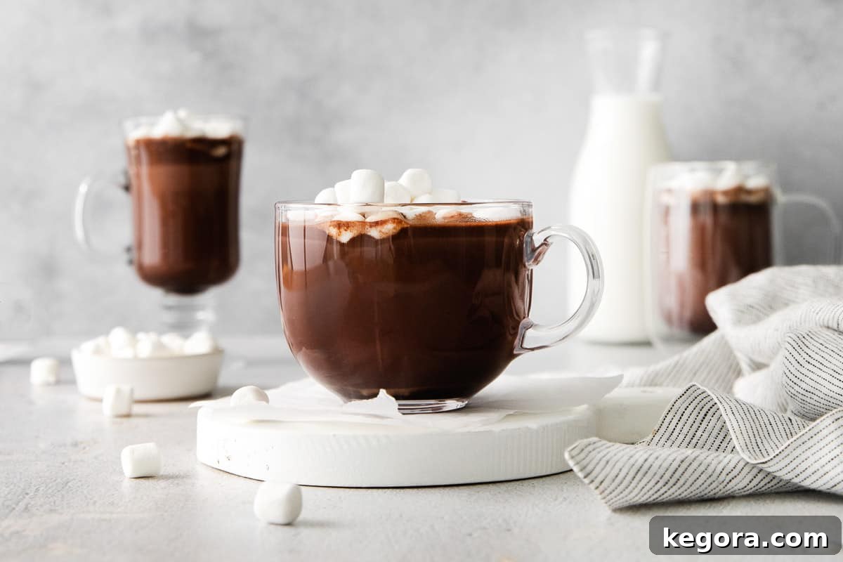 A wide shot of three mugs of hot chocolate, garnished with marshmallows