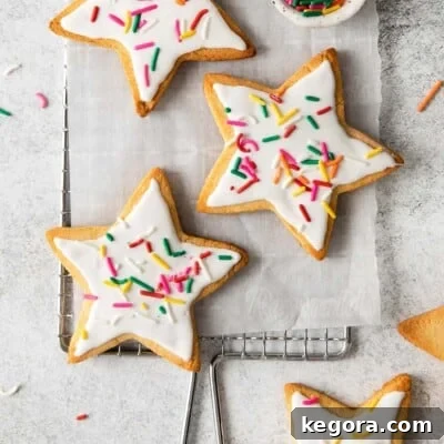 almond flour sugar cookies topped with white frosting and sprinkles