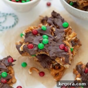 gluten free christmas pretzel treats on parchment paper topped with M&Ms