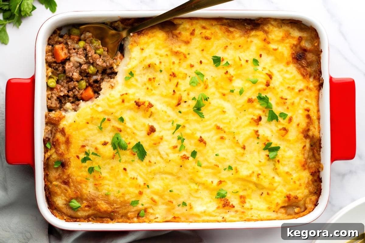 Baked Irish Cottage Pie in a baking dish with a portion scooped out, revealing the rich filling.