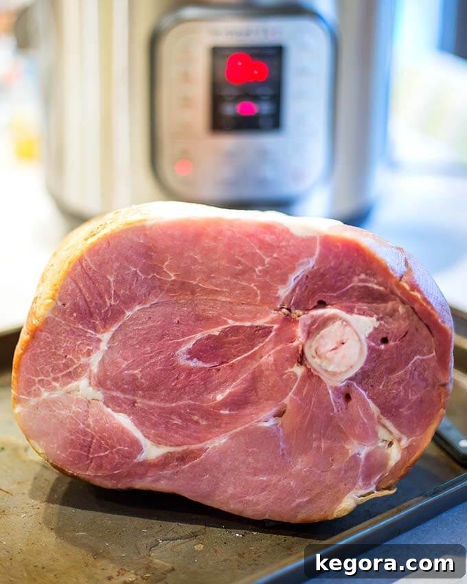 Bone-in Ham on baking sheet with pressure cooker in background