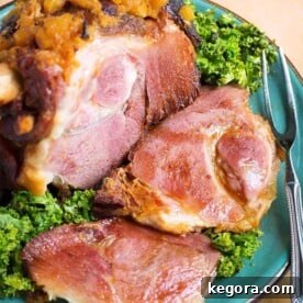 Bone-in Ham on turquoise plate with fork and green leaf garnish