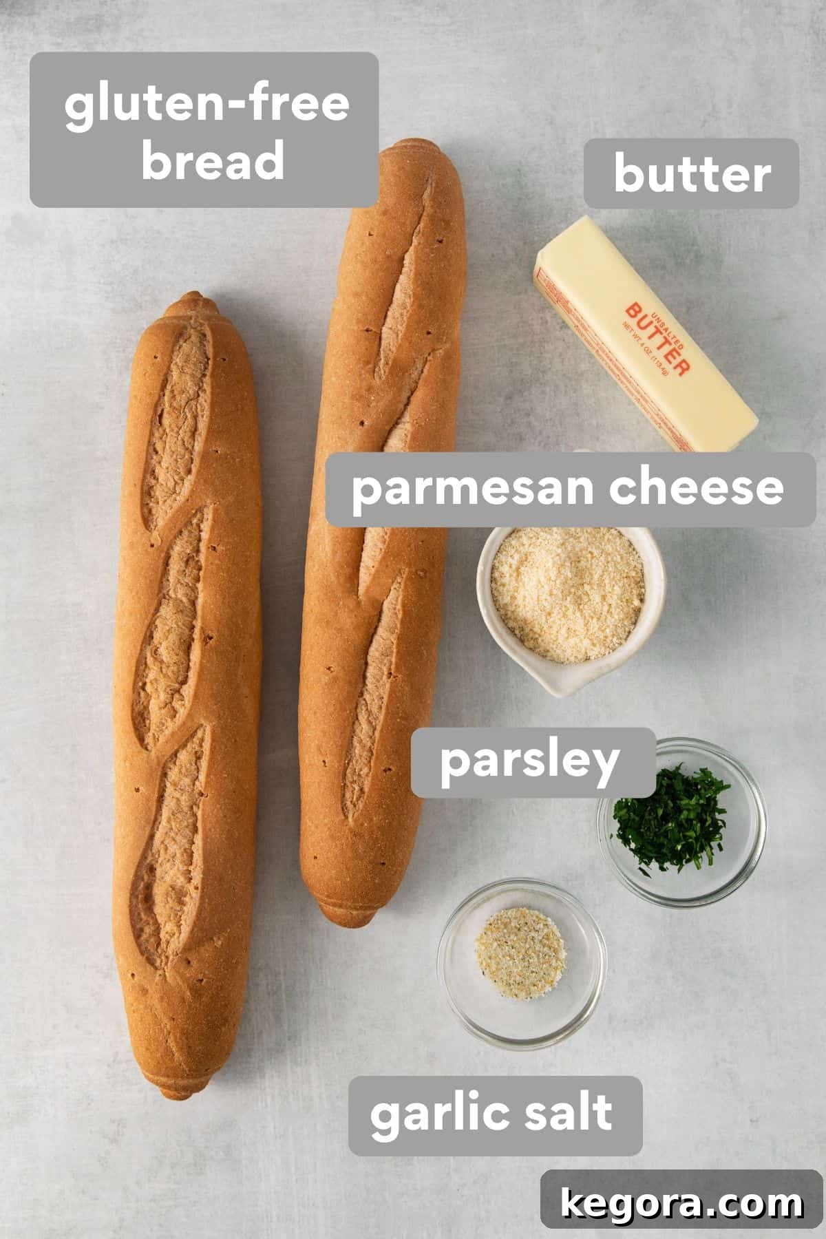 A flat lay image showing the simple ingredients for gluten-free garlic bread arranged on a kitchen countertop.