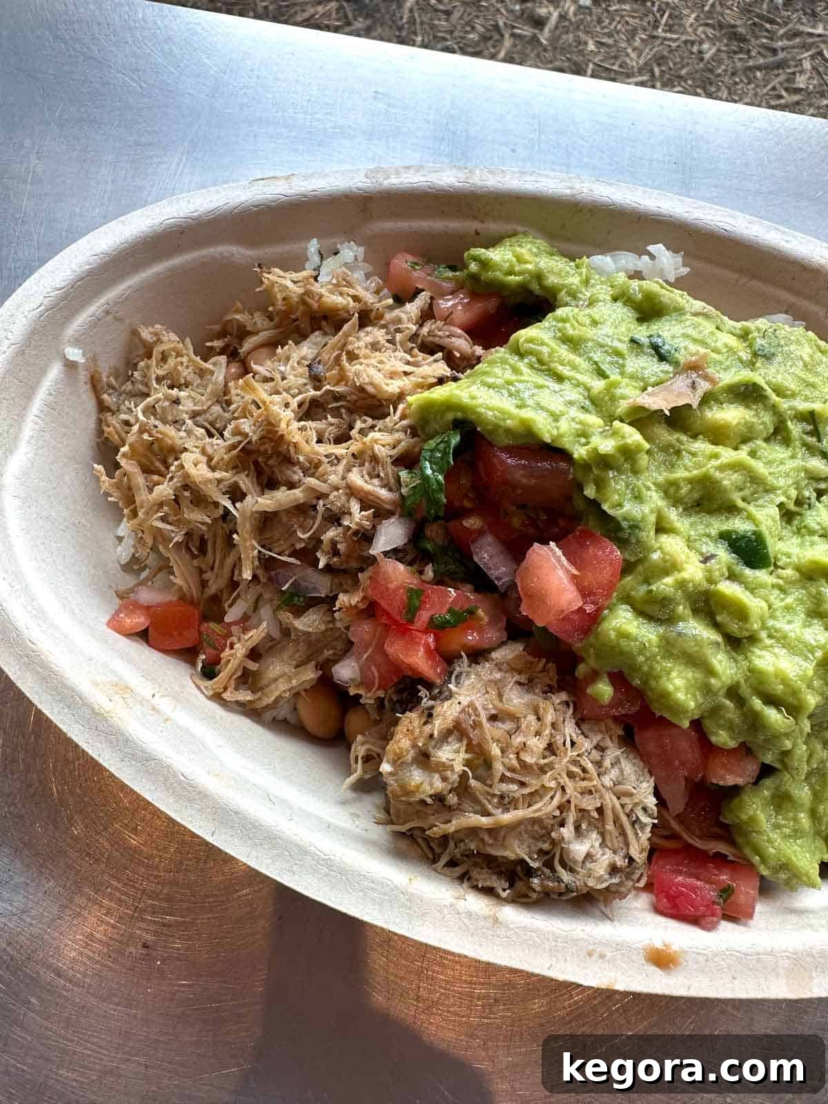 Close-up photo of a gluten-free burrito bowl from Chipotle, topped with guacamole.