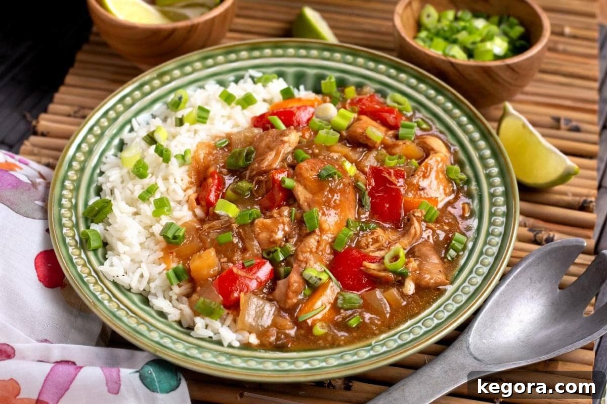 A vibrant close-up of Slow Cooker Pineapple Chicken on a green plate with white rice, ready to be enjoyed.