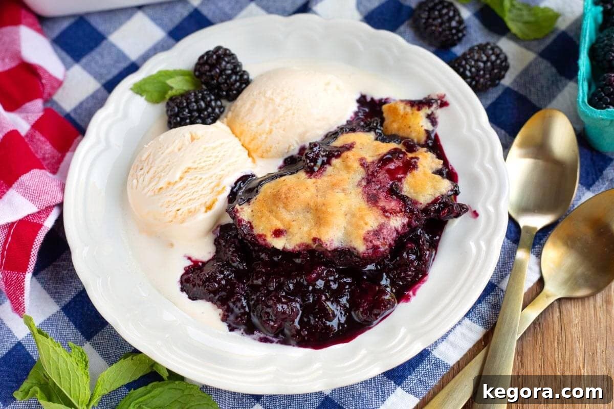 A beautifully presented plate of Homemade Blackberry Cobbler with a scoop of vanilla ice cream, ready to be enjoyed.