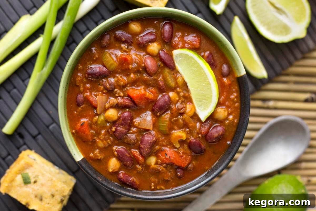 A bowl of rich Instant Pot Chili, garnished with a vibrant lime wedge and fresh green onions.