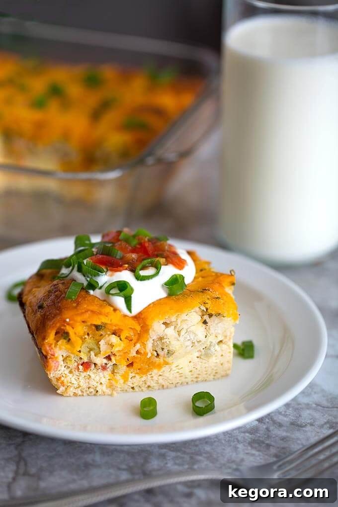 A perfectly portioned slice of Southwest Breakfast Egg Bake on a white plate, accompanied by a glass of milk and a silver fork, highlighting its fluffy texture.