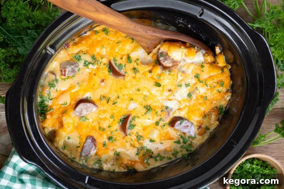 Crockpot Cheesy Potatoes with Kielbasa in a black crock
