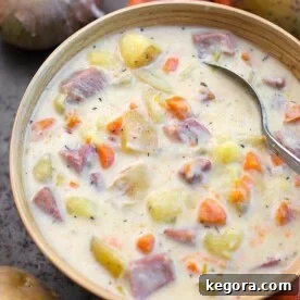 Instant Pot Potato Ham Soup in a beige bowl with veggies