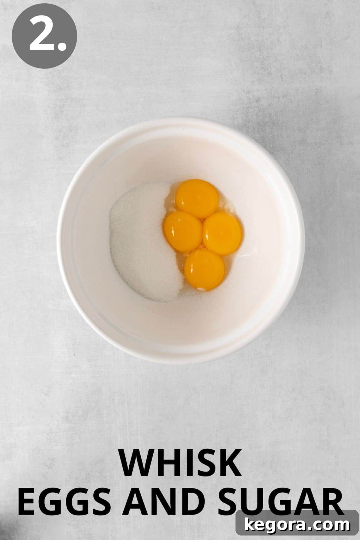 Dairy-Free Dream Brûlée 5 A close-up shot of egg yolks, granulated sugar, and a pinch of salt thoroughly whisked together in a mixing bowl, creating a smooth and light yellow mixture.