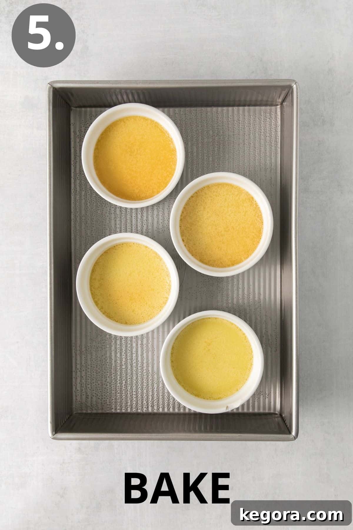 Dairy-Free Dream Brûlée 8 A tray of four perfectly baked dairy-free creme brulee custards in ramekins, removed from the oven and cooling, with their centers still slightly jiggly.