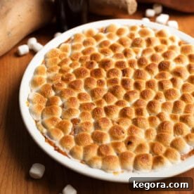 Instant Pot Candied Yams - Sweet Potatoes with golden marshmallow topping in a white dish.