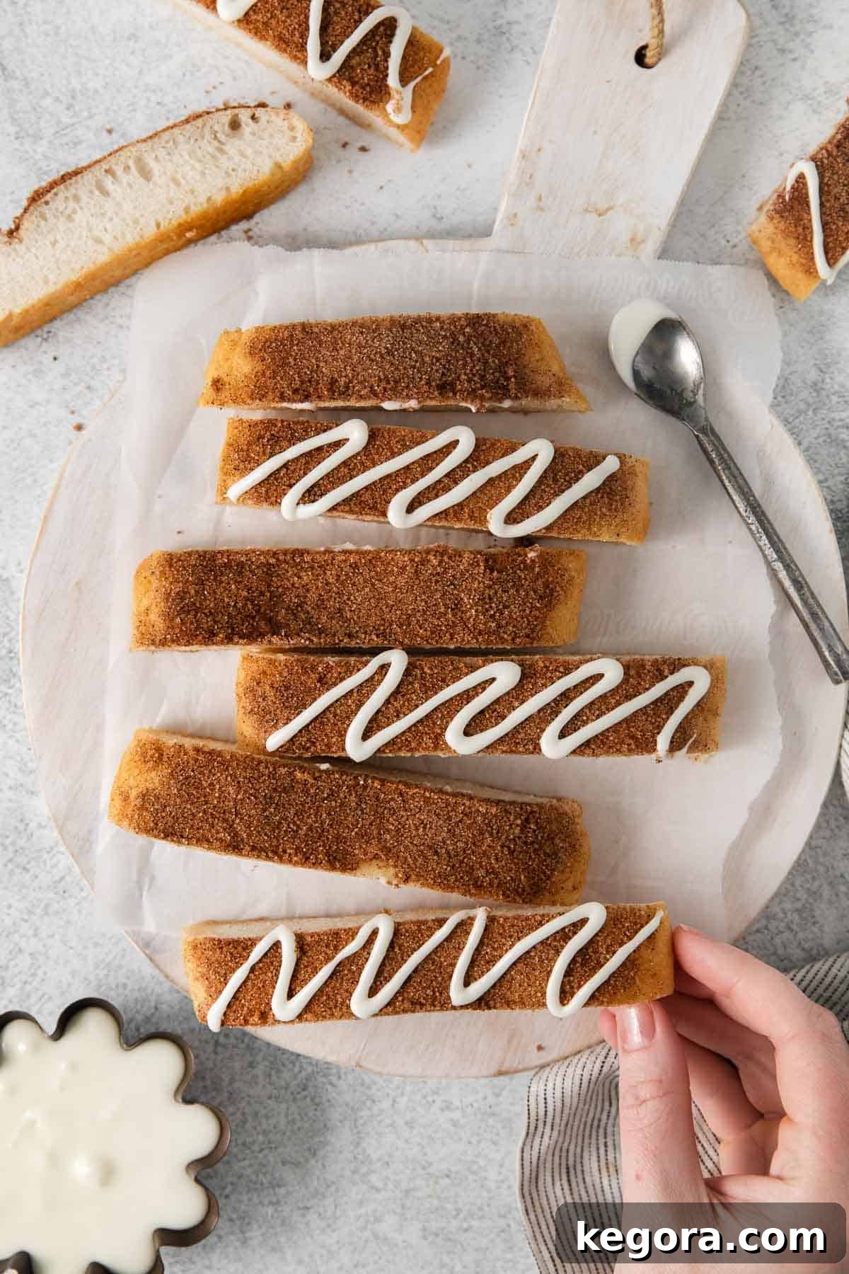 Sweet Cinnamon Gluten-Free Dippers 2 Gluten-free cinnamon breadsticks on a platter, with a hand picking up a breadstick