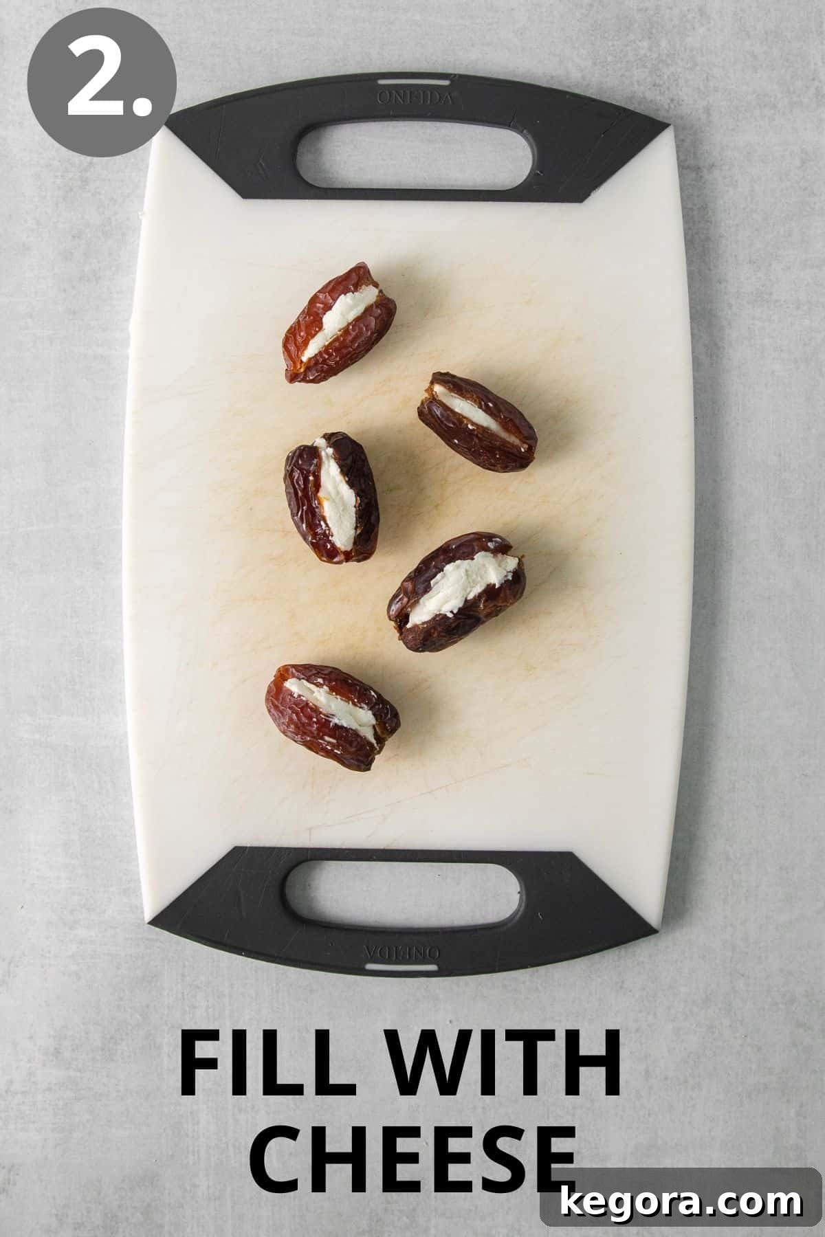 Dates filled with creamy goat cheese on a cutting board.