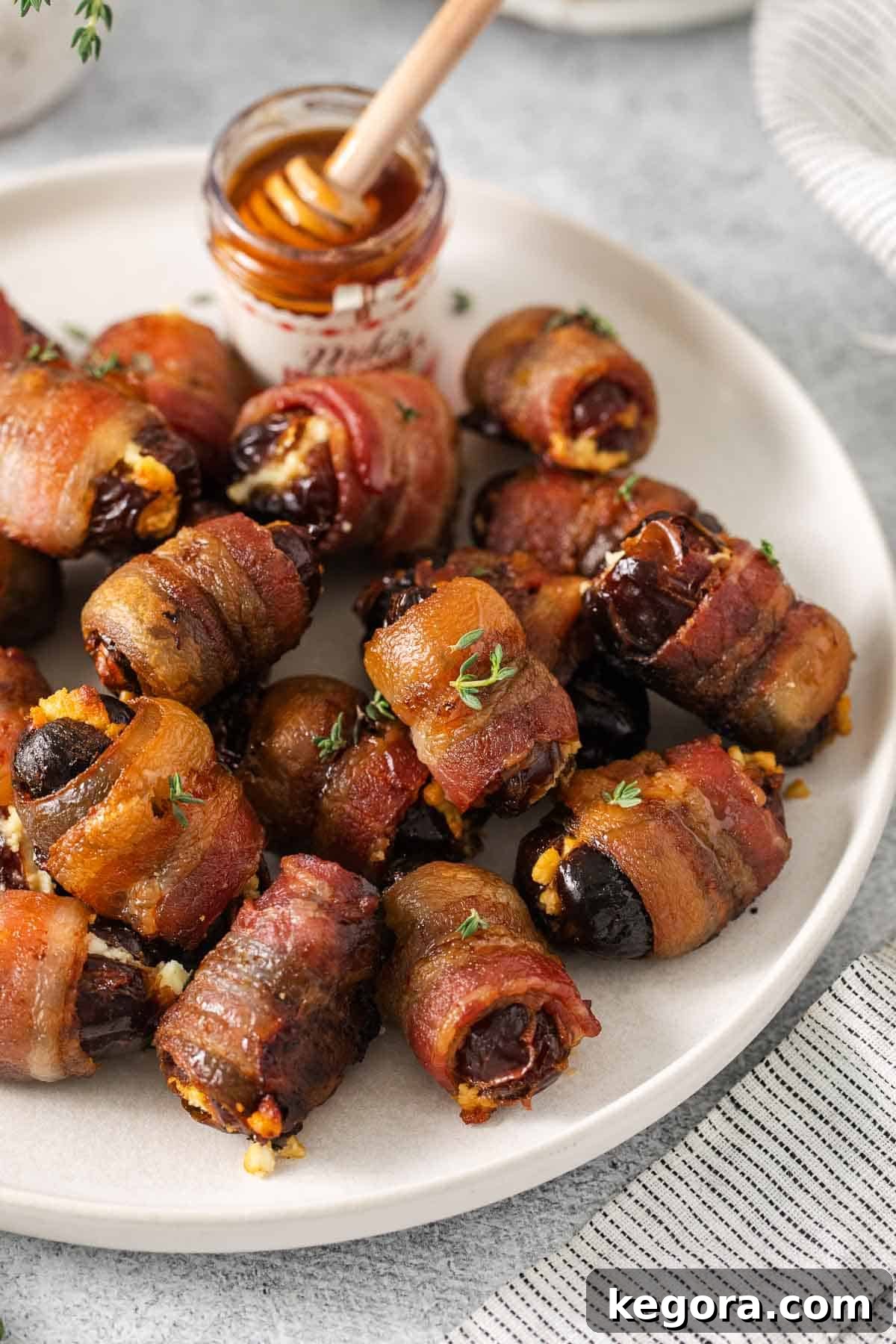 A closeup photo of bacon-wrapped dates artfully arranged on a serving plate.