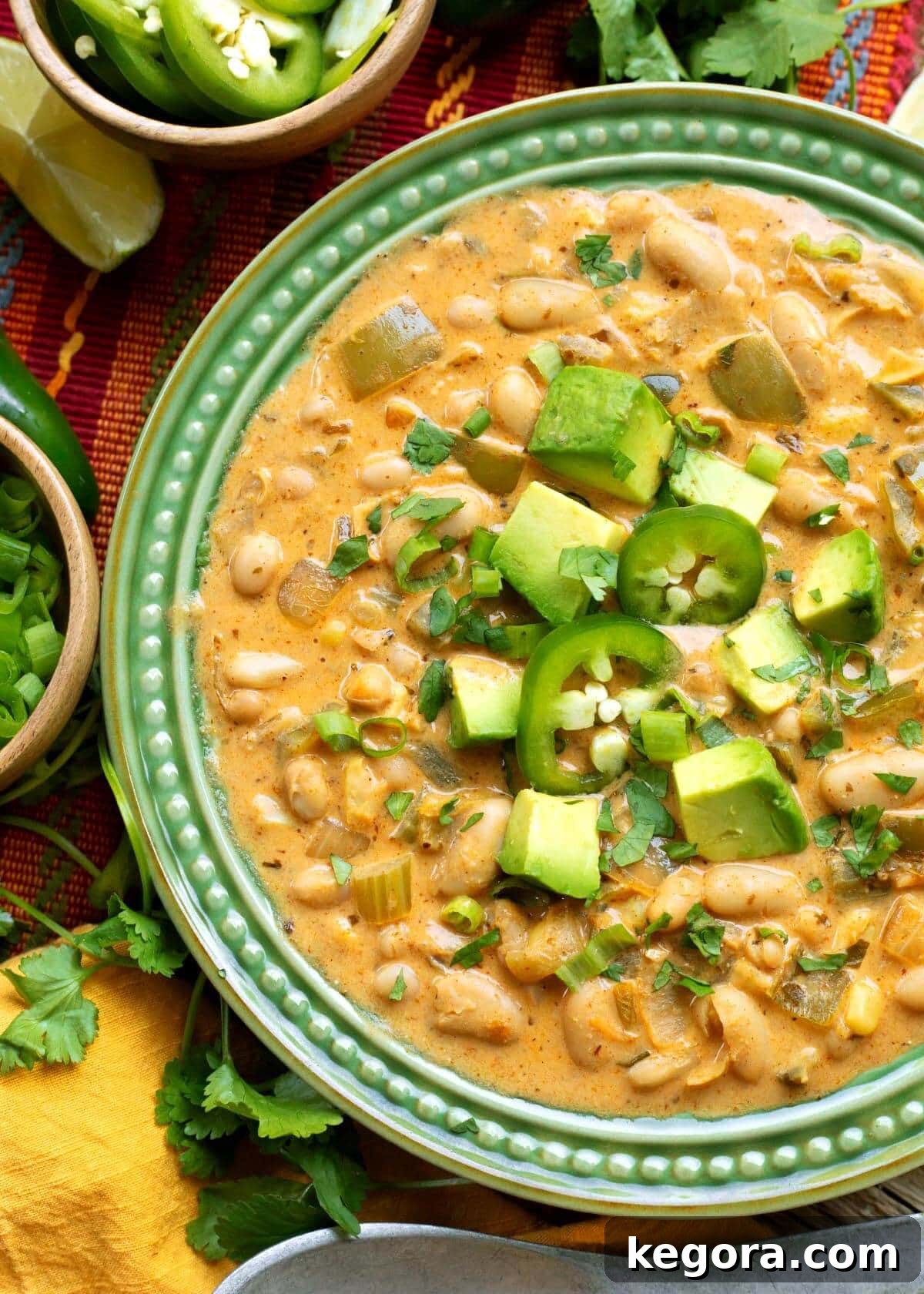 Plant-Powered White Bean Chili 2 Creamy Vegetarian White Bean Chili in a green bowl, garnished with fresh cilantro and lime