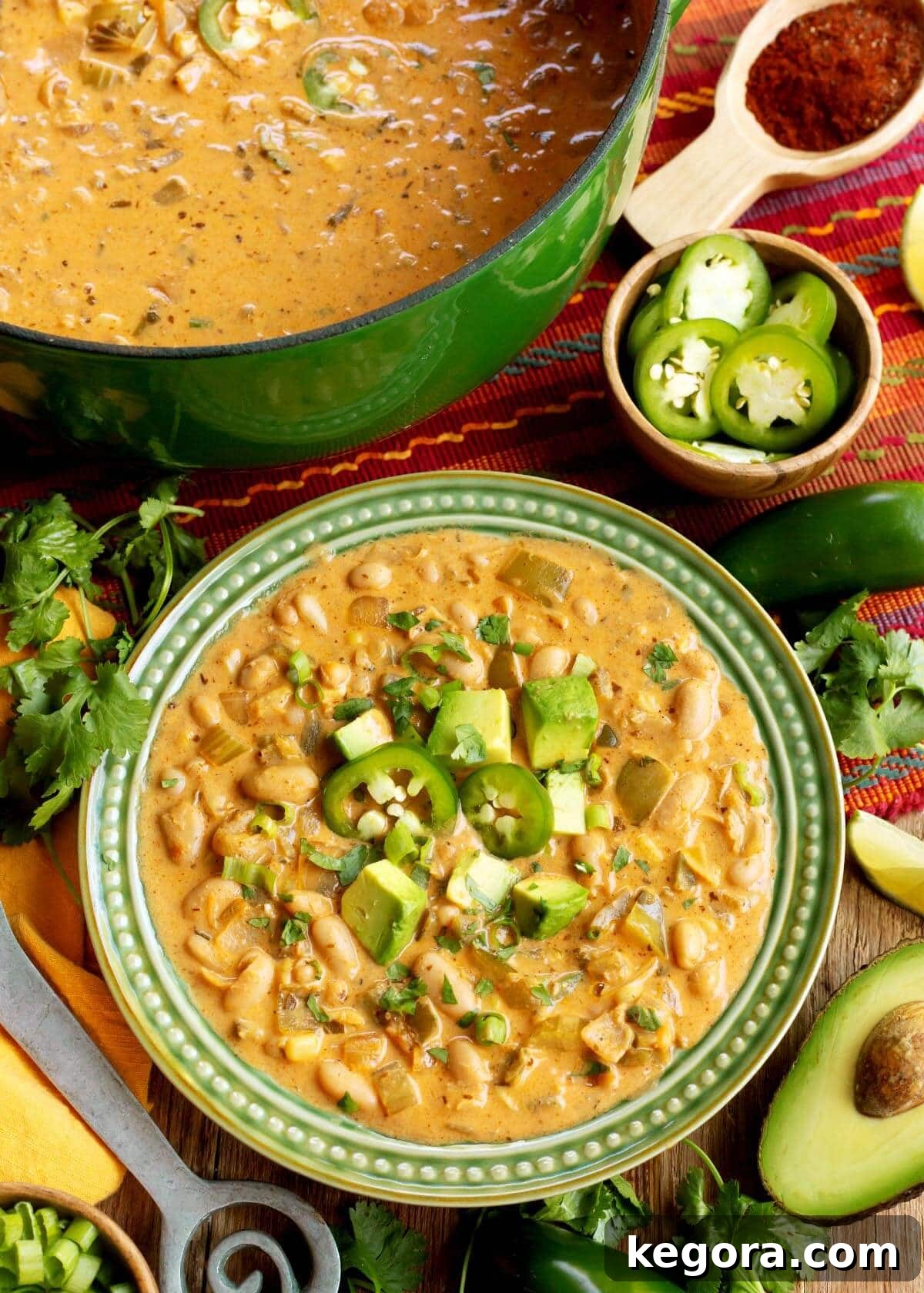 Plant-Powered White Bean Chili 11 Vegetarian White Bean Chili in a green bowl and a green pot, ready to serve