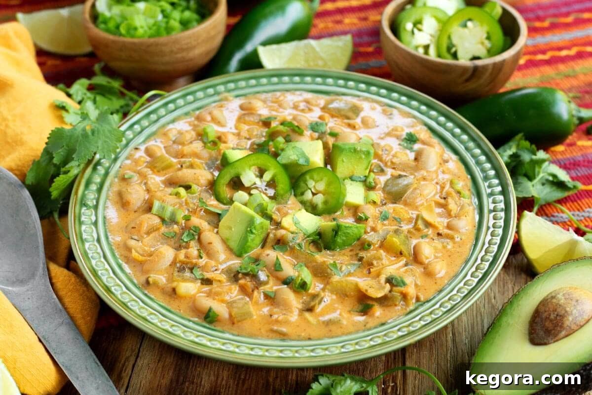 Plant-Powered White Bean Chili 12 Close-up of a serving of Vegetarian White Bean Chili in a green bowl, garnished with cilantro