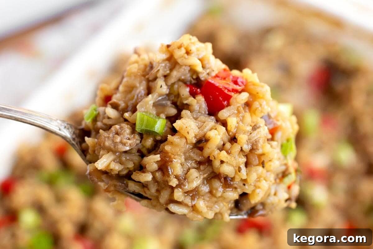 Close-up of a spoonful of Hamburger Rice Casserole, showcasing the perfectly cooked rice and ground beef.