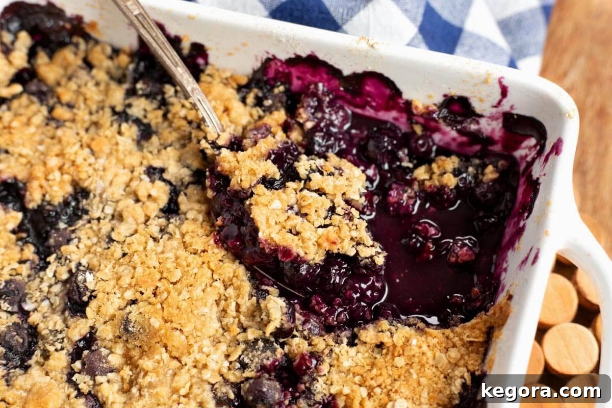 Easy Blueberry Crisp in baking dish with serving spoon