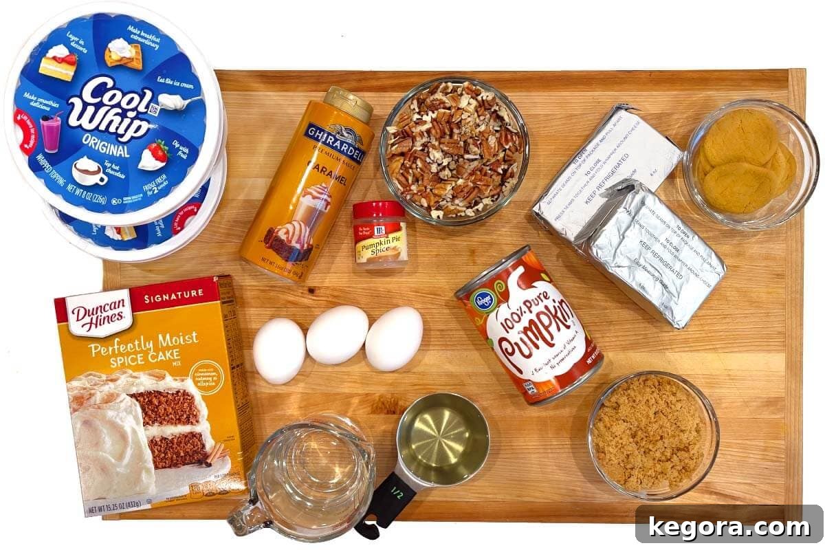 Stunning Make Ahead Pumpkin Trifle Fall Favorite 4 Pumpkin trifle ingredients laid out on a wooden board, including cake mix, pumpkin puree, spices, and cream cheese.