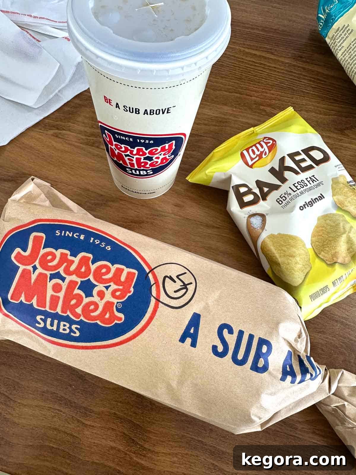 wrapped up sandwich labeld gf with baked lays and drink
