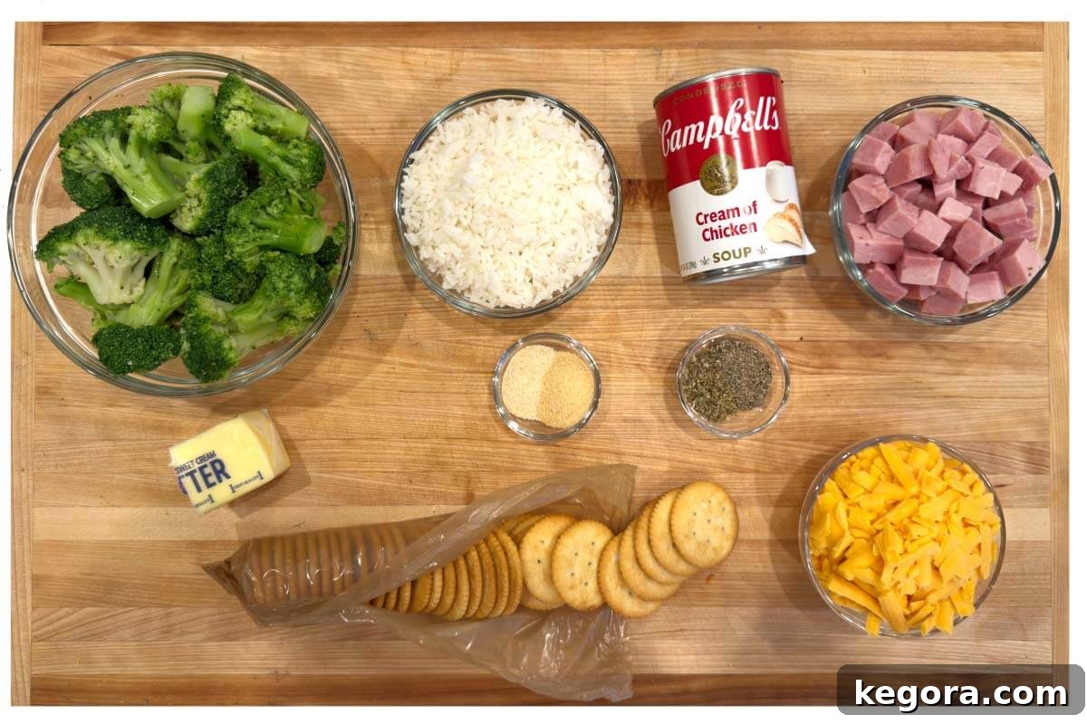 Hearty Ham and Broccoli Rice Bake 4 Various ingredients for Ham and Broccoli Rice Casserole laid out on a wooden surface, including ham, broccoli, rice, cheese, soup, and spices.