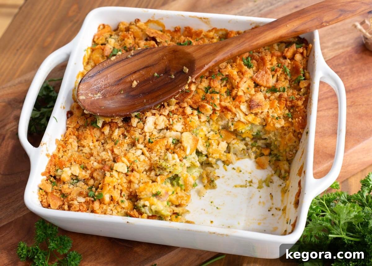 Hearty Ham and Broccoli Rice Bake 8 Baked Ham and Broccoli Rice Casserole in a baking dish with a portion scooped out, showcasing the creamy texture and golden topping.
