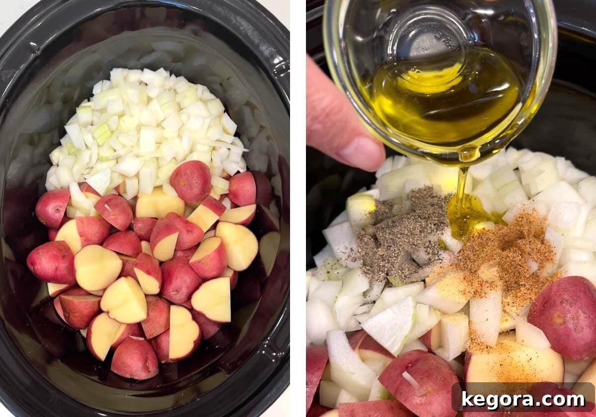 Chopped potatoes and onion mixed with olive oil and spices in the bottom of a slow cooker, ready for layering.