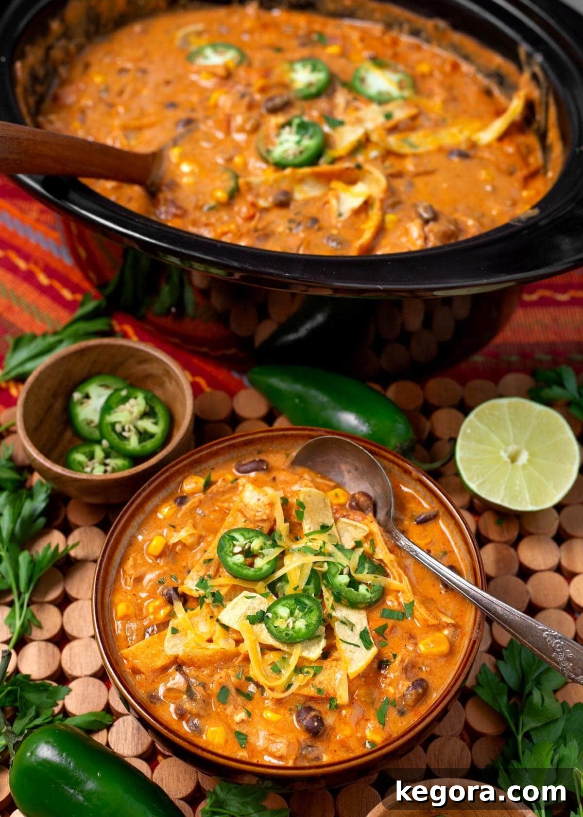 Slow Cooker Southwest Chicken Tortilla Soup 2 A steaming bowl of Crockpot Chicken Tortilla Soup, garnished with fresh cilantro and lime wedges, showcasing its rich texture and vibrant colors.