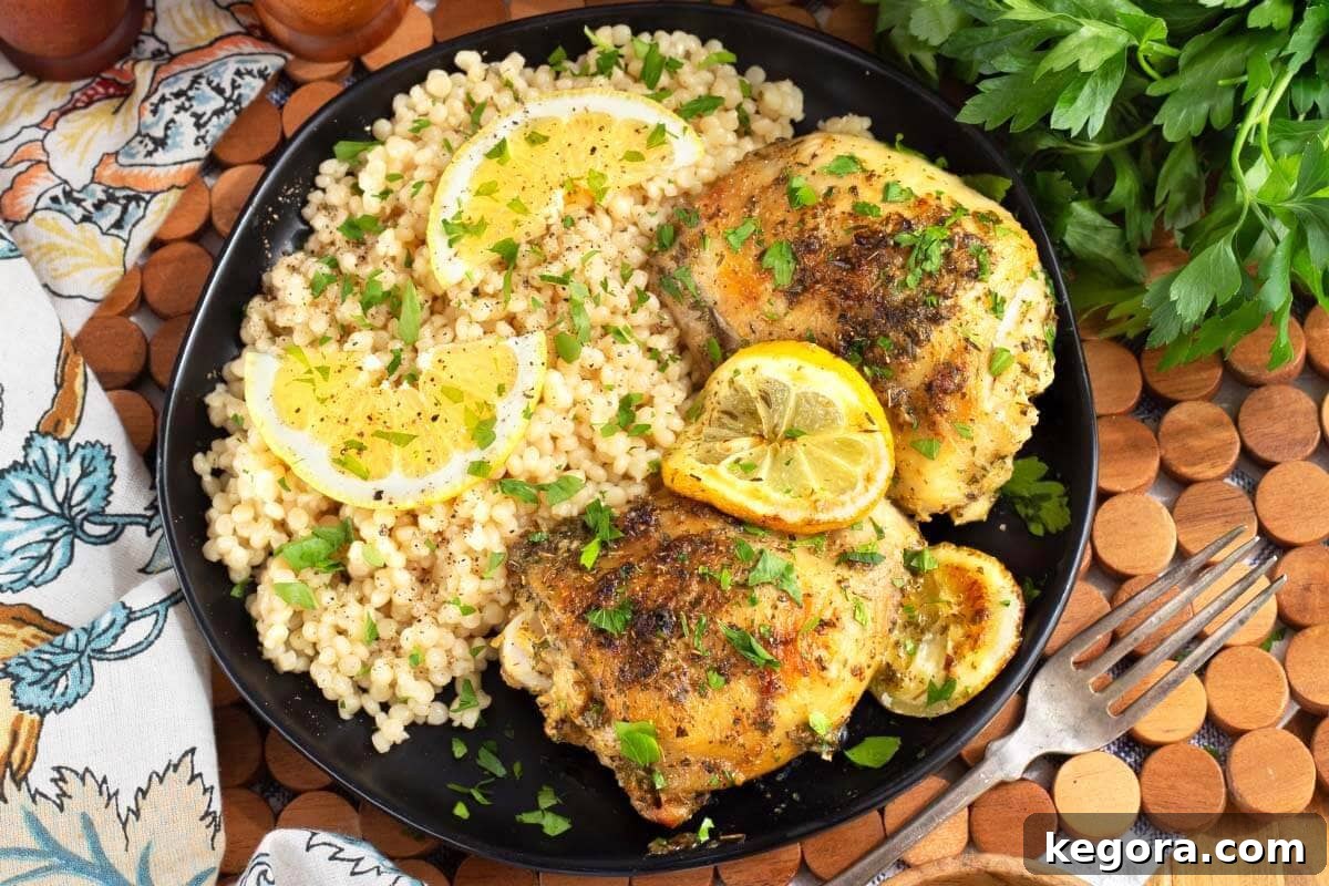 Zesty Greek Chicken Thighs 3 Close-up of baked Greek Lemon Chicken Thighs in a baking dish, with crispy skin and juicy interior.