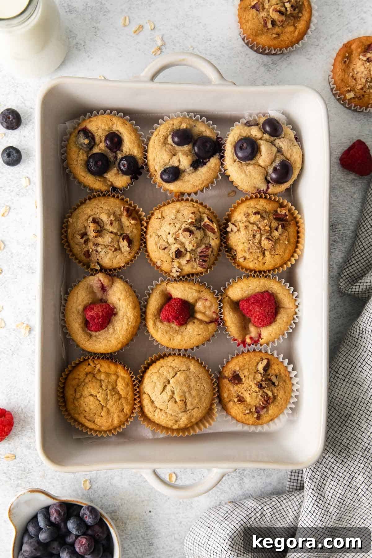 Wholesome Oat Muffins Infinite Variations 3 Freshly baked oat flour muffins arranged in a white baking dish, ready to be served.