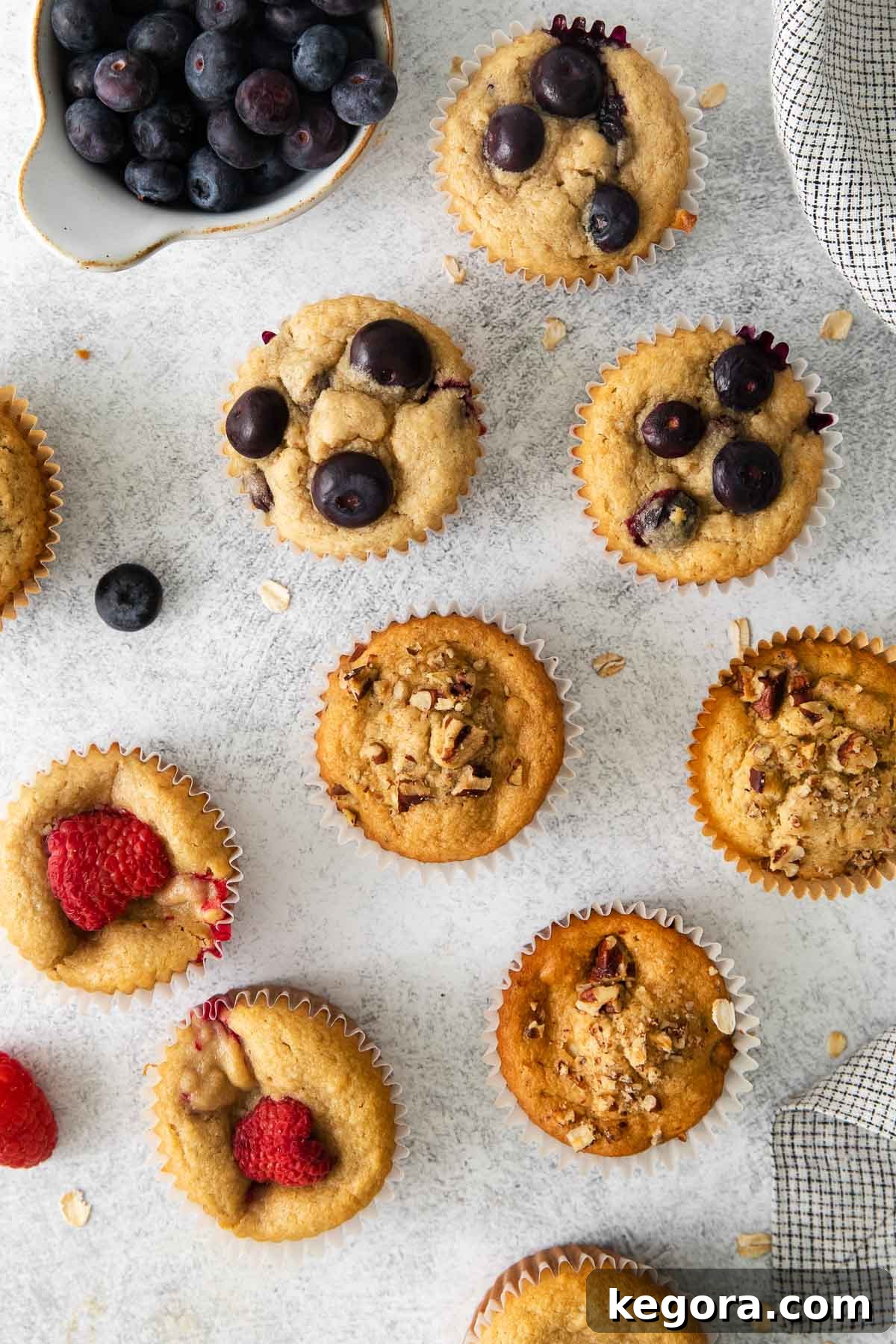 Wholesome Oat Muffins Infinite Variations 8 A vibrant spread of baked oat flour muffins on a rustic countertop, surrounded by fresh berries and fruit, emphasizing their natural goodness.