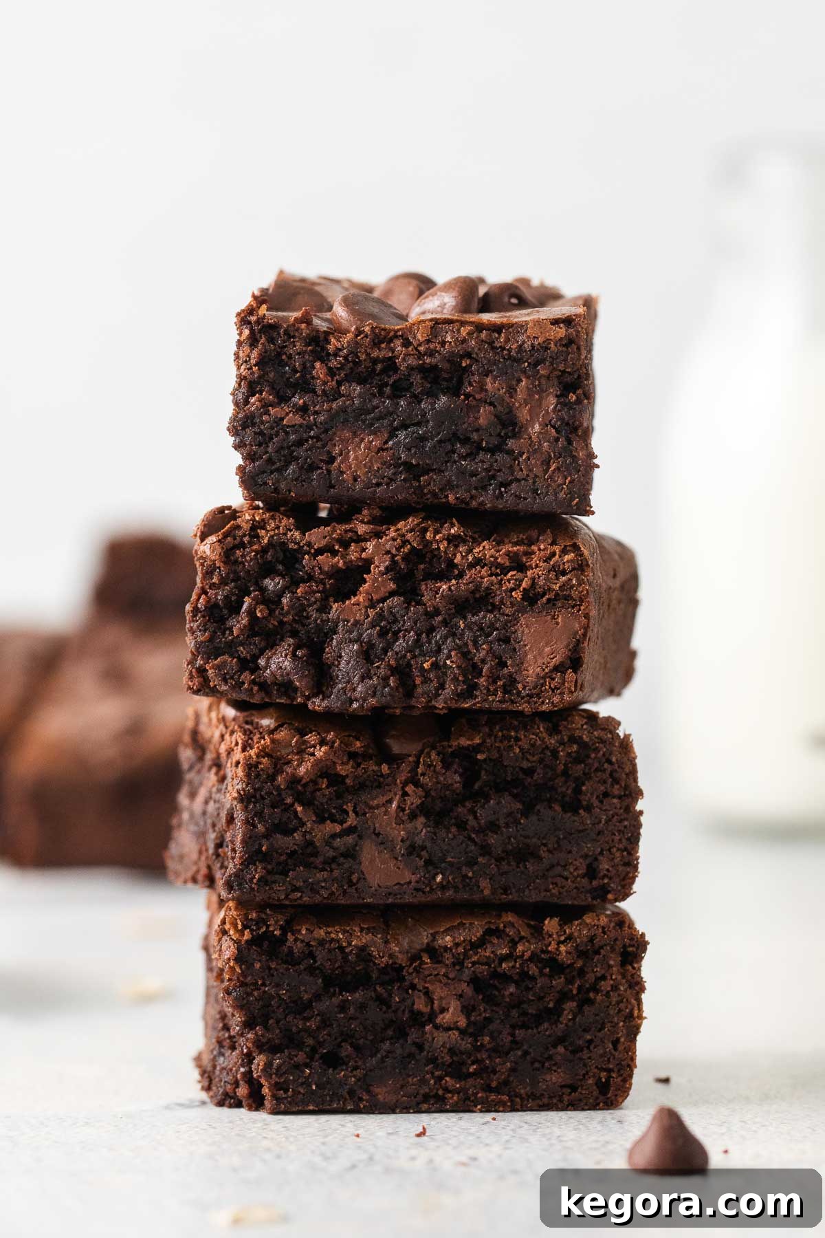 A stack of perfectly baked oat flour brownies on a countertop, garnished and ready to be enjoyed