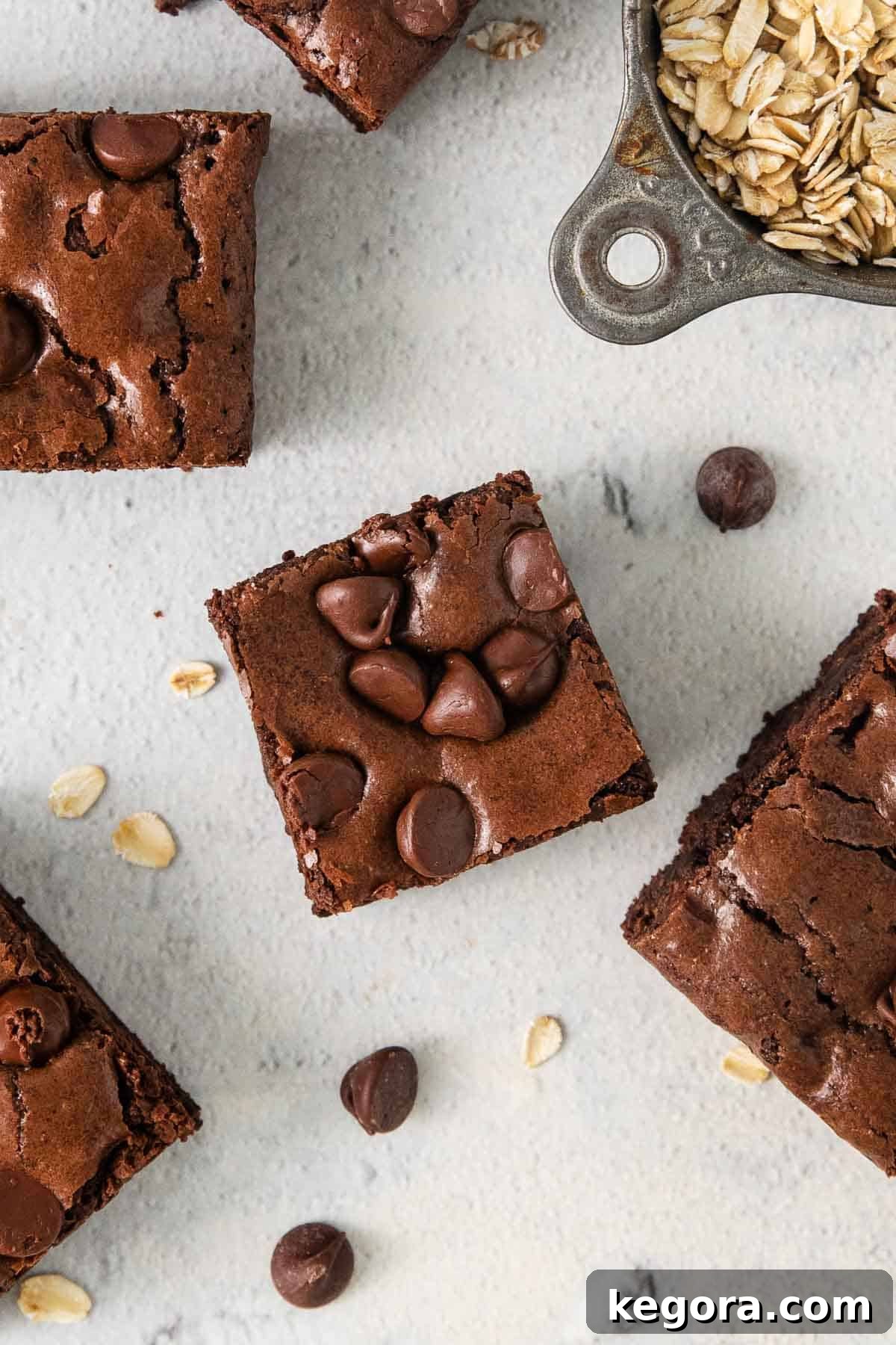 Close-up of baked oat flour brownies on a kitchen counter, showing their delicious top layer